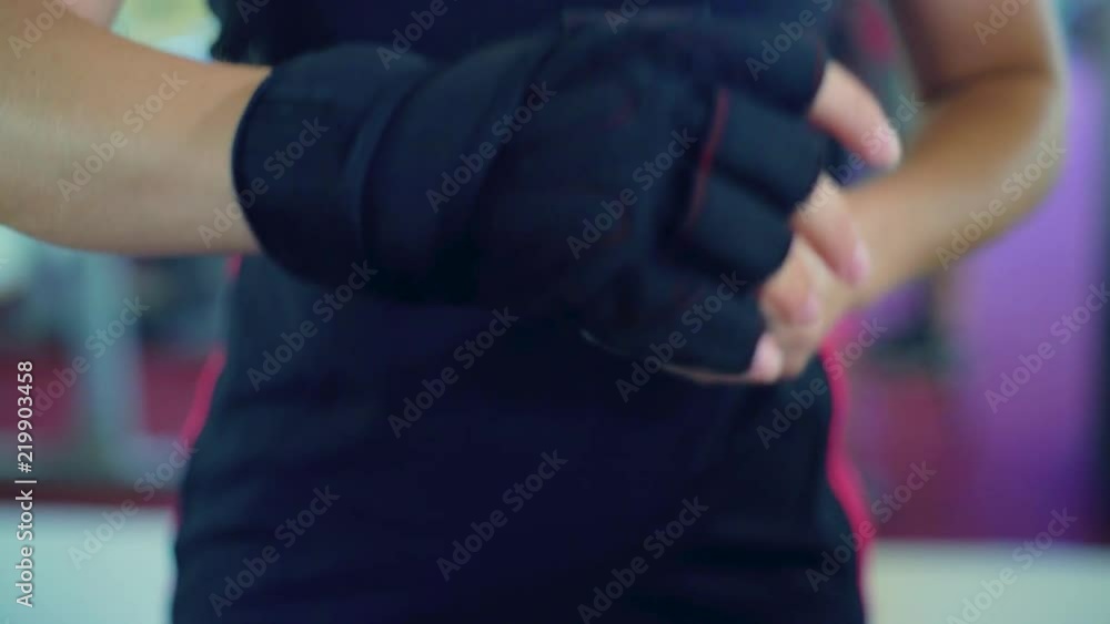 Closeup woman putting protective gloves in the gym. Healthy lifestyle. Wellness, sport and cardio workout concept Closeup woman putting protective gloves in the gym. Healthy lifestyle. Wellness, sport and cardio workout concept