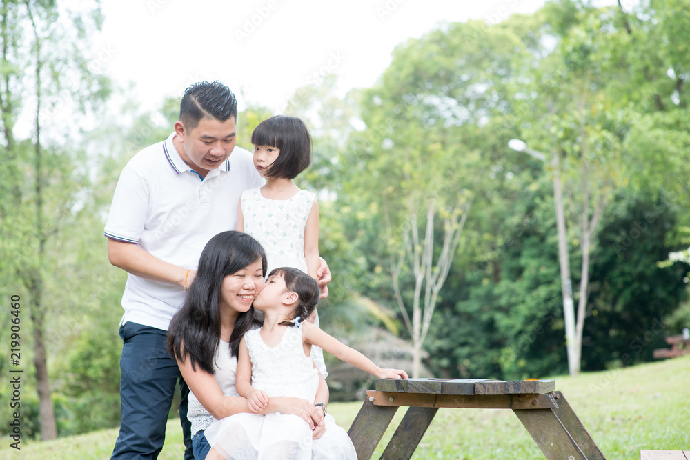 Happy Asian family portrait with empty table space. Happy Asian family portrait with empty table space.