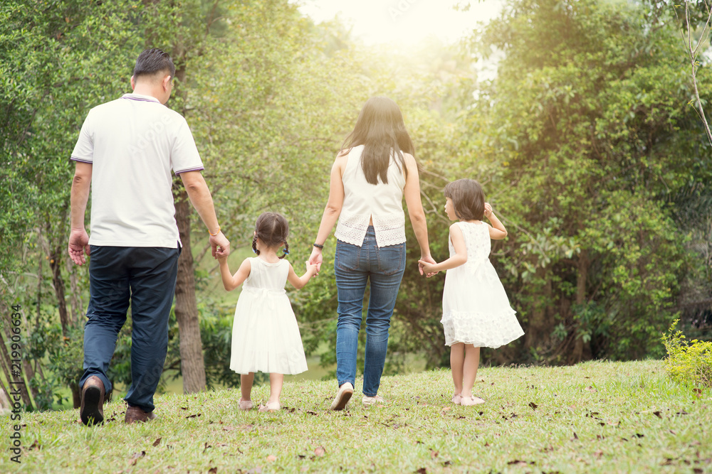Asian family hold hands and walking at outdoor park, back view. Asian family hold hands and walking at outdoor park, back view.