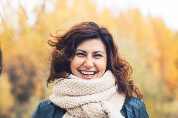 Autumn portrait of cheerful woman in fall park outdoors, portrait. Girl laughing