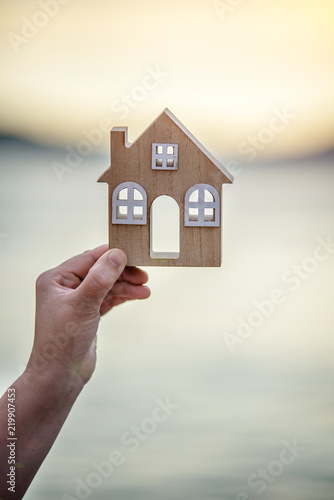 Girl holding the symbol of the house over the sea 