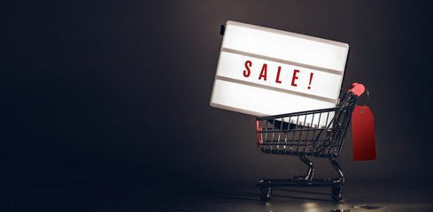 Sale light box in shopping cart with price tag at dark studio room banner size.Mock up header leave space for adding text or design for promote business campaign on line.