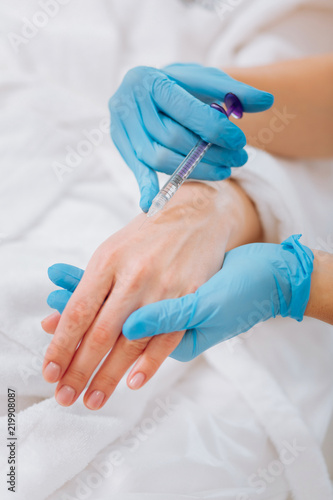 Staying beautiful. Injection being done in the female hand during the procedure in the beauty salon