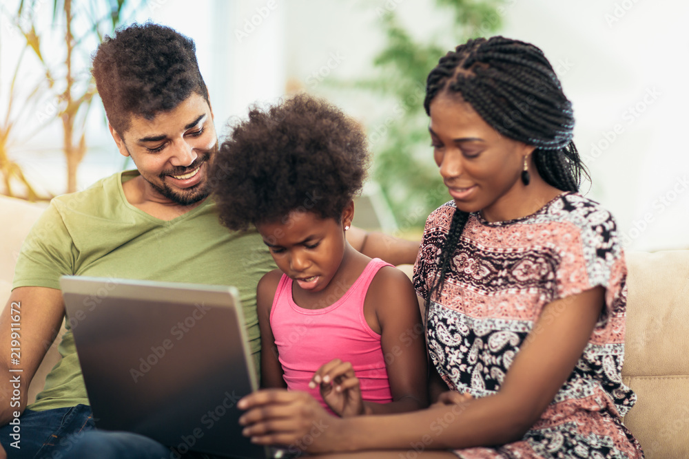 African american family using laptop in the living room. African american family using laptop in the living room.