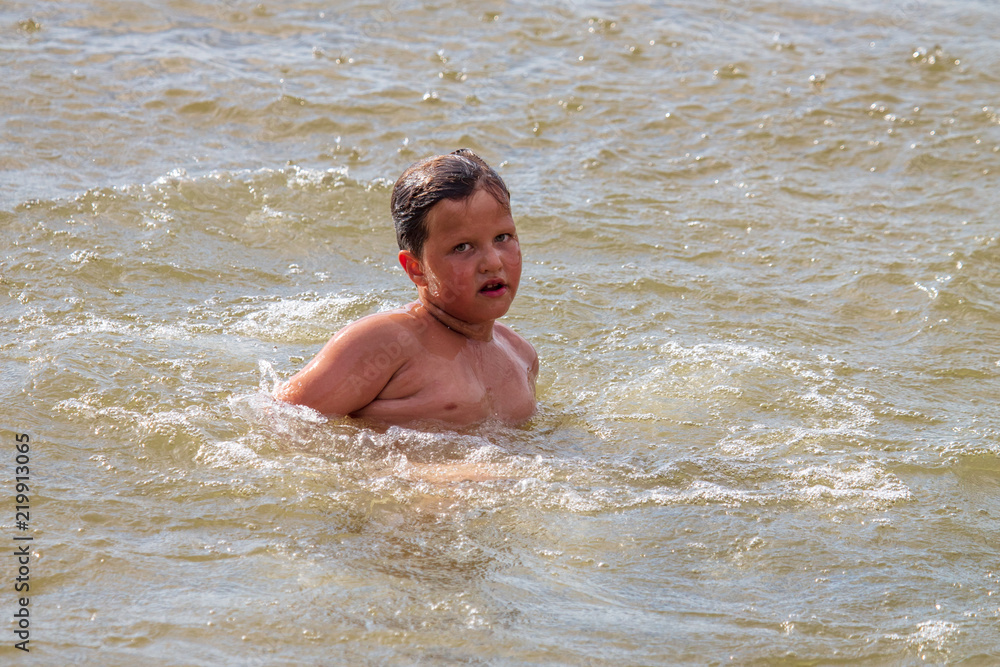 The boy is swimming on the beach The boy is swimming on the beach