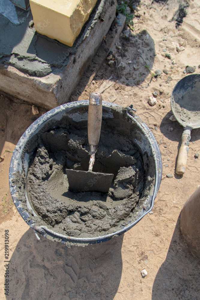 The worker mixes the concrete mixture at the construction site The worker mixes the concrete mixture at the construction site