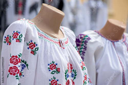 Traditional linen shirt with embroidered flowers and ornaments weared on mannequin at local market at state fair © lainen