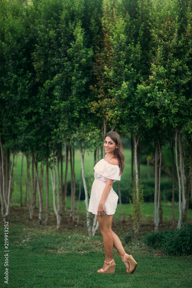young and pretty girl in a summer city standing near the tree young and pretty girl in a summer city standing near the tree