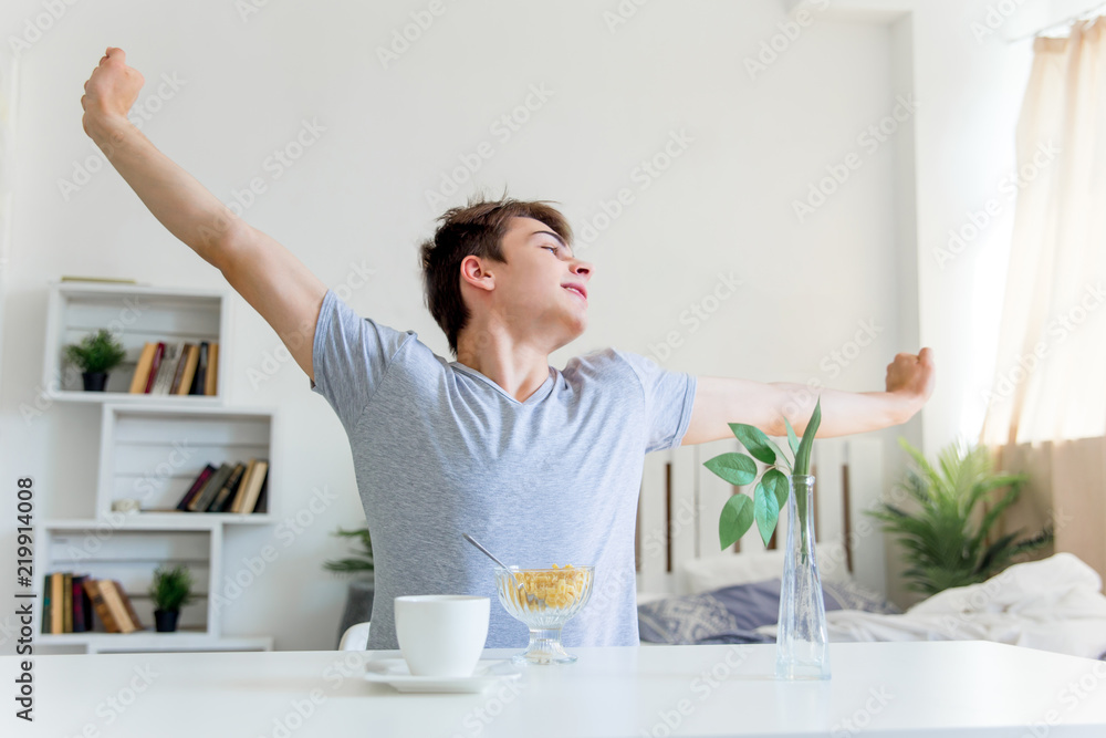 Young man drinking coffee and having breakfast Young man drinking coffee and having breakfast