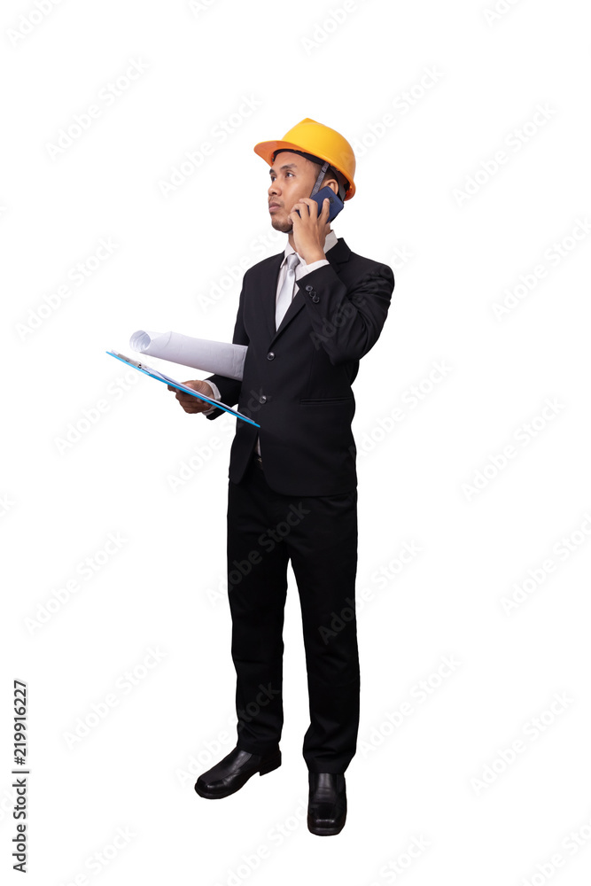 full portrait of Asian engineer man standing isolated on white background with clipping path. engineer with yellow safety helmet have blueprint in hand , holding paper file and using mobile phone full portrait of Asian engineer man standing isolated on white background with clipping path. engineer with yellow safety helmet have blueprint in hand , holding paper file and using mobile phone