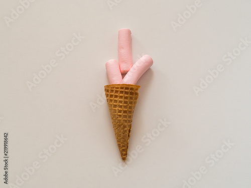 Marshmallow in ice cream cone on white