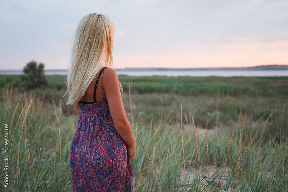 Blonde in a sundress enjoys the sunset Blonde in a sundress enjoys the sunset