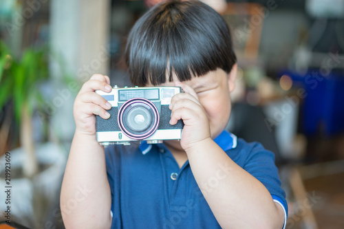 A boy is taking a Photo film camera. © No-Te