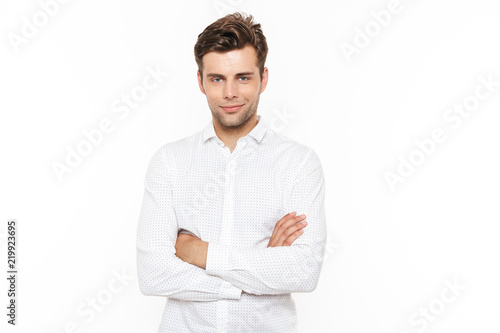 Image of happy smiling man 30s with bristle posing on camera with hands crossed, isolated over white background