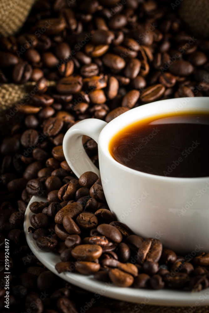 Coffee cup and beans on a rustic background. Coffee Espresso and a piece of cake with a curl. Cup of Coffee and coffee beans on table. Coffee cup and beans on a rustic background. Coffee Espresso and a piece of cake with a curl. Cup of Coffee and coffee beans on table.