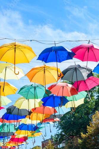 Different colorful umbrellas hanging over the street against sky © ihorbondarenko