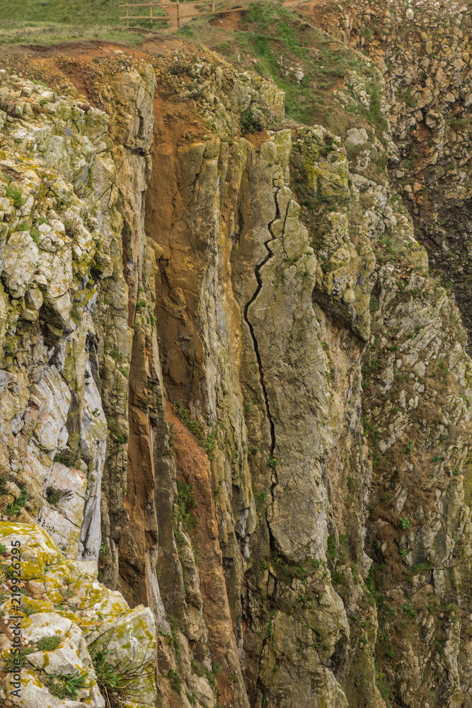 Huge crack on the face of a limestone cliff at Skrinkle Haven on the Pembrokeshire Coast in South Wales Huge crack on the face of a limestone cliff at Skrinkle Haven on the Pembrokeshire Coast in South Wales