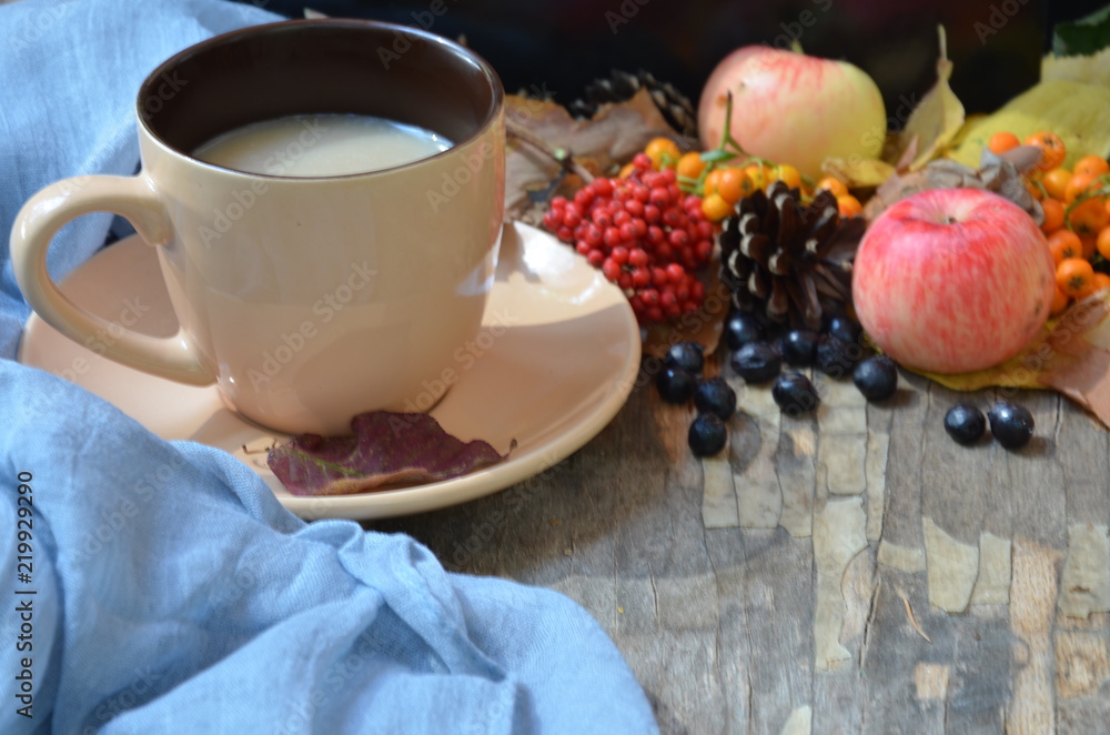 Flat lay of composed cup with black coffee on wood table with ripe berries of rowan and dark foliage. Cappuccino or latte or tea on a vintage table. fallen leaves, ripe apples, berries. Copy space Flat lay of composed cup with black coffee on wood table with ripe berries of rowan and dark foliage. Cappuccino or latte or tea on a vintage table. fallen leaves, ripe apples, berries. Copy space