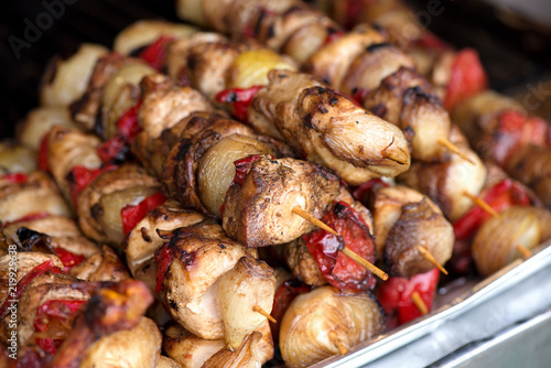 Close up of traditionally grilled pork and beef meat on a wooden stick. Eastern European traditional shish kebab with grilled vegetables.