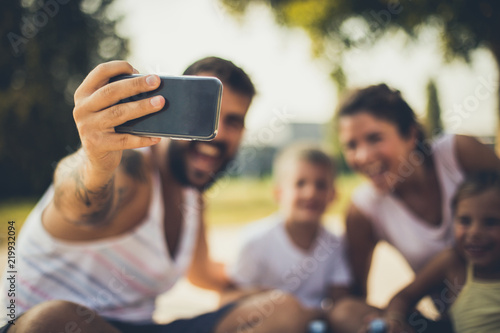 Happy family taking selfie . Father holding smart phone.