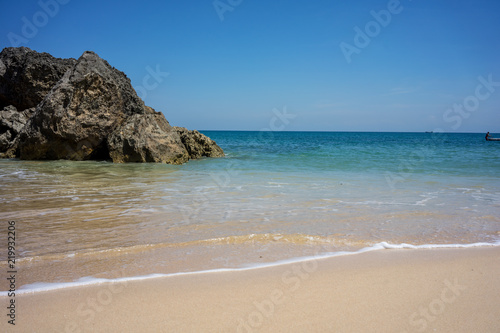 beach with rock cliff sand and ocean waves
