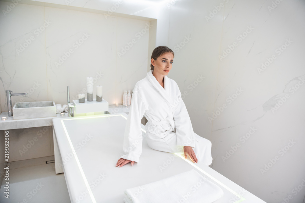Waiting for procedure. Serene beautiful girl spending time at modern spa cabinet for relaxing Waiting for procedure. Serene beautiful girl spending time at modern spa cabinet for relaxing