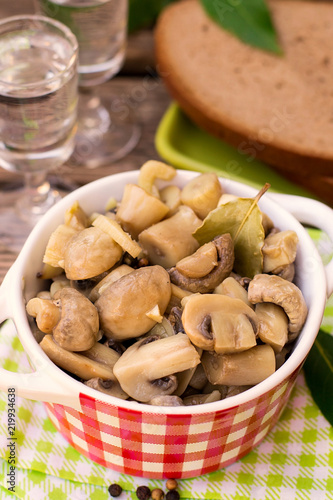 Pickled marinated button mushrooms with pepper and bay leaf