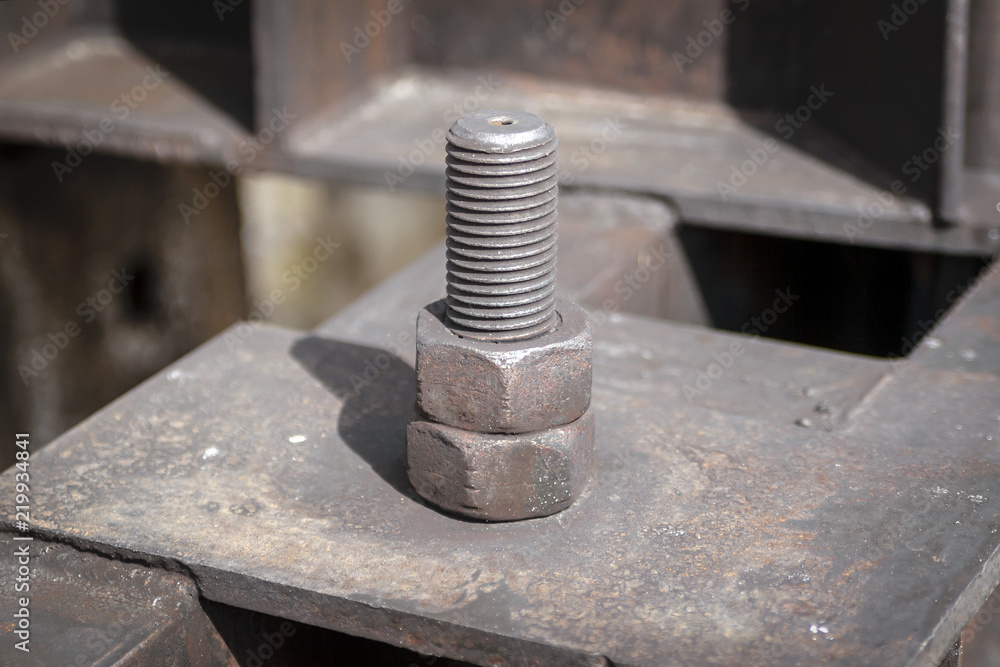 The old nut is screwed to the bolt. Close-up. The old nut is screwed to the bolt. Close-up.