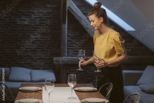 Fotografie Woman Setting up Dinner Table