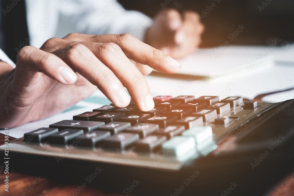 Businessman is using calculators to calculate and analyze the company budget. Businessman is using calculators to calculate and analyze the company budget.