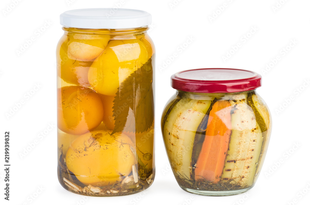 Glass jars with pickled yellow tomatoes and grilled zucchini slices Glass jars with pickled yellow tomatoes and grilled zucchini slices