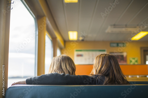 Two girls enjoying the view from their seats on a ferry in the San Juan Islands.