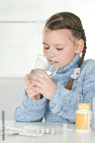Close up portrait of young sick girl drinking while sitting