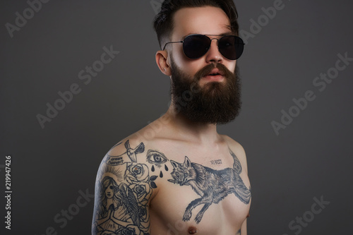 Bearded Man in sunglasses, naked tattoed Boy