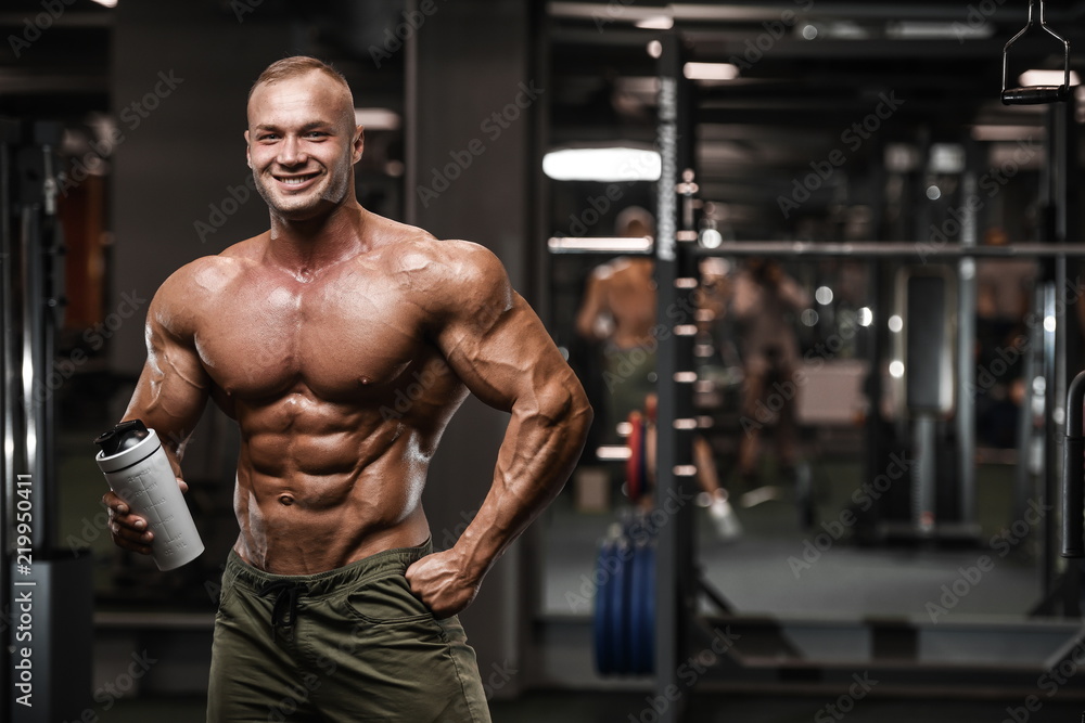Handsome strong bodybuilder athletic men pumping up muscles with dumbbells Handsome strong bodybuilder athletic men pumping up muscles with dumbbells