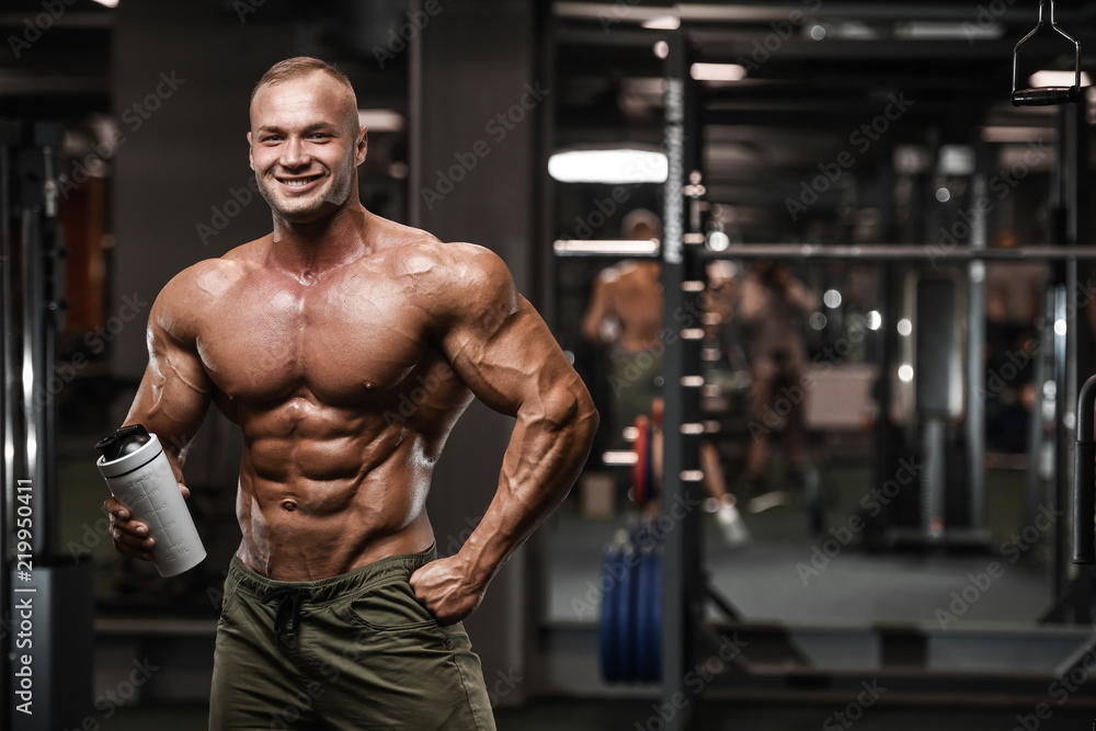 Handsome strong bodybuilder athletic men pumping up muscles with dumbbells