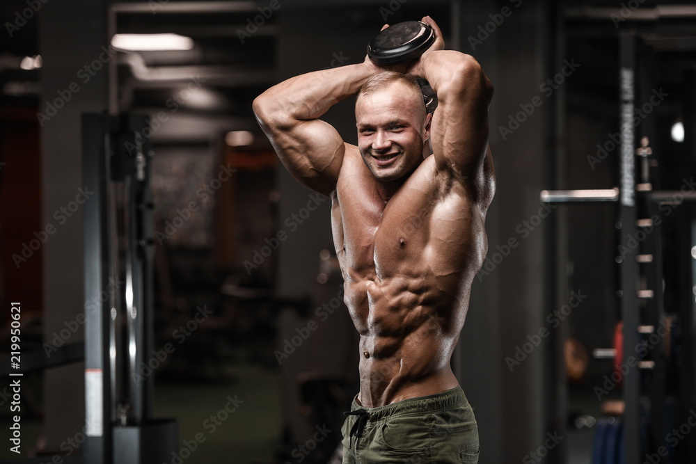Handsome strong bodybuilder athletic men pumping up muscles with dumbbells Handsome strong bodybuilder athletic men pumping up muscles with dumbbells