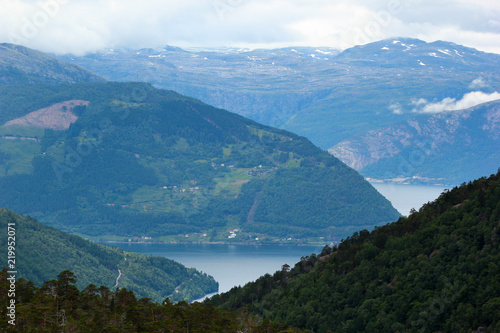View of Husedalen valley with cascade of four waterfalls and Kinsarvik fjord, Norway