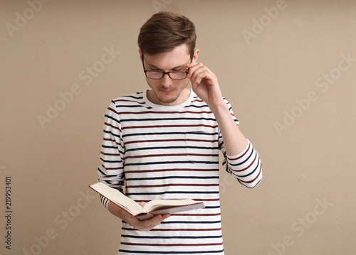 Young man reading book on c...