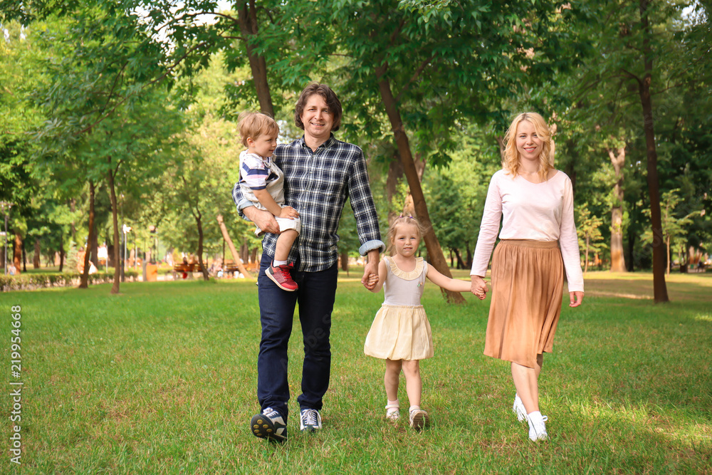 Happy family walking in green park