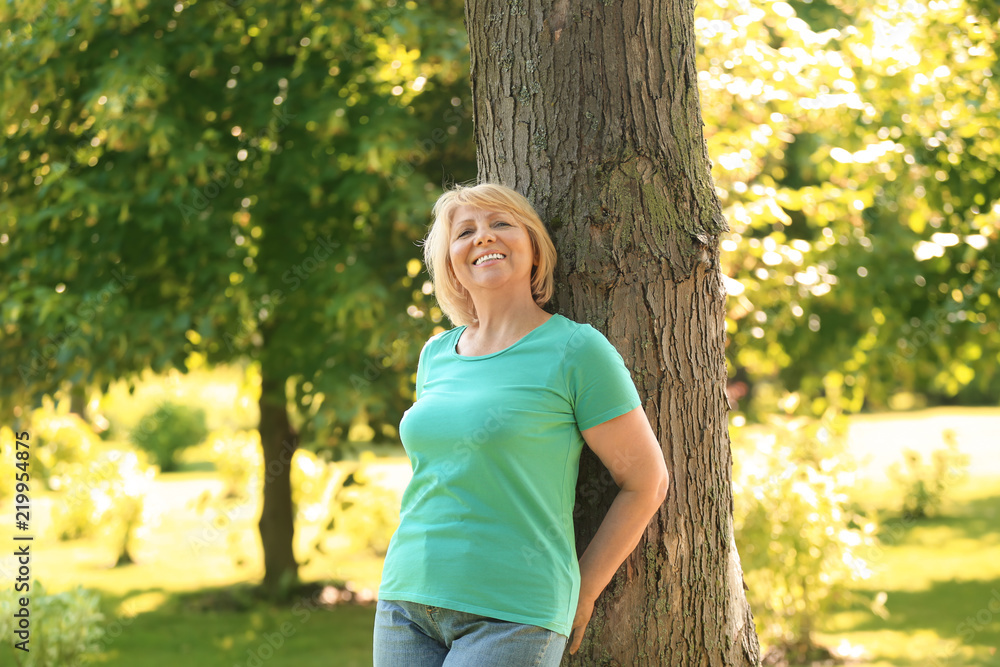 Portrait of beautiful mature woman in green park Portrait of beautiful mature woman in green park
