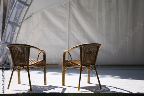 Two wicker chairs against the sky and palm trees photo