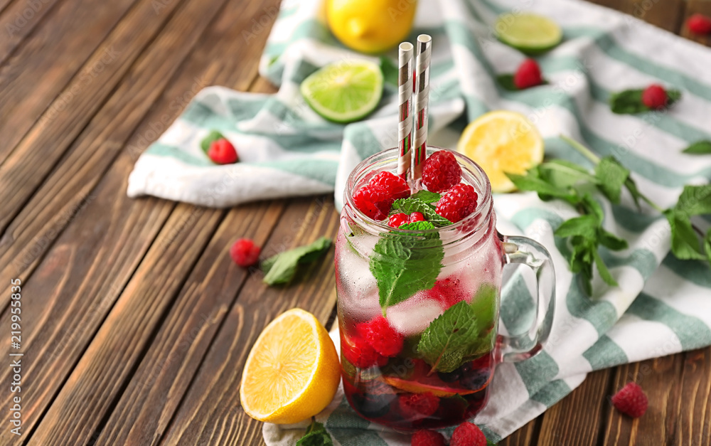 Mason jar of fresh raspberry mojito on wooden table Mason jar of fresh raspberry mojito on wooden table