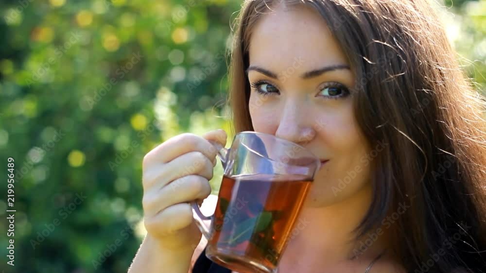Young woman smiling and drinking black tea with mint on outdoor Young woman smiling and drinking black tea with mint on outdoor