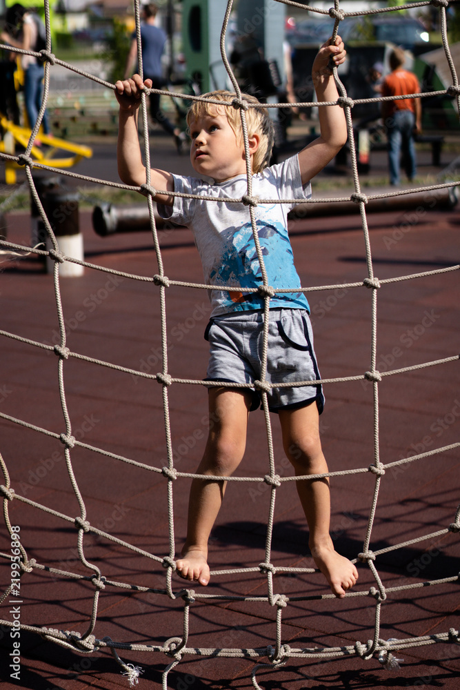 life of children in a modern city - little boy is having fun on the playground near the house life of children in a modern city - little boy is having fun on the playground near the house