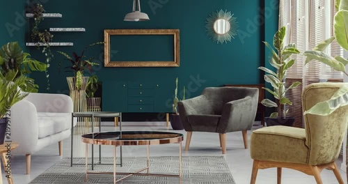 Video of green living room interior with plants with furniture like copper table, armchairs and sofa disappearing