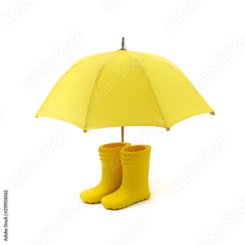 A pair of yellow rain boots and a umbrella on a white