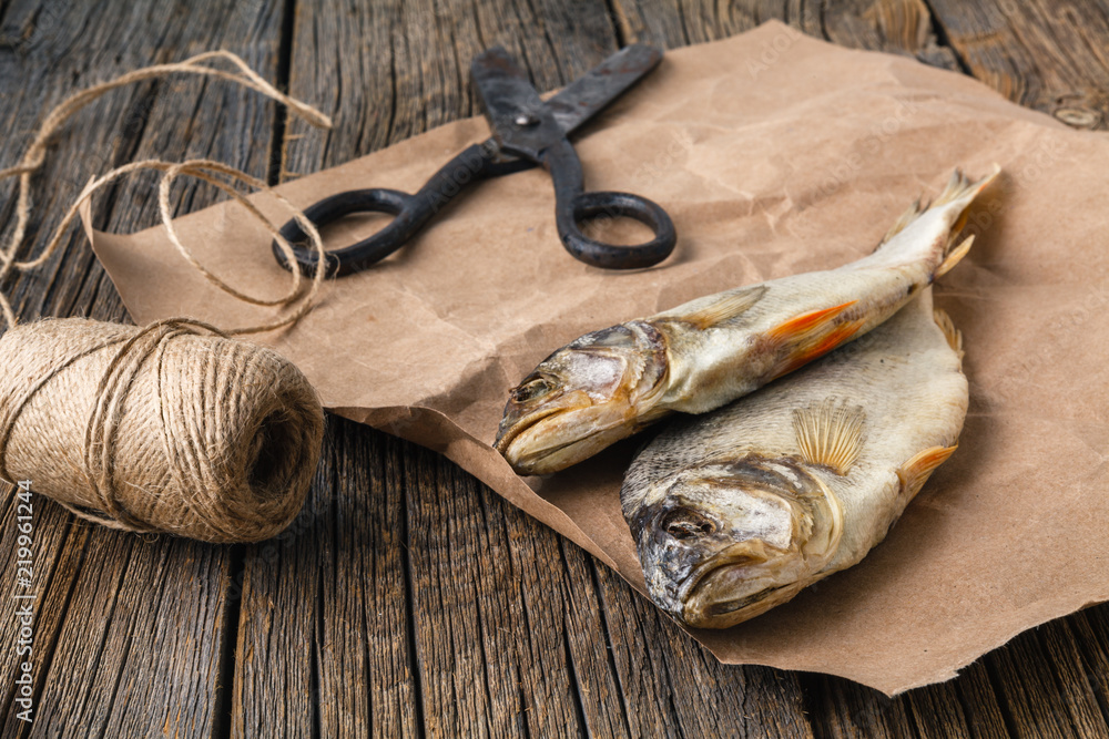 Dried salty herring fishes on a wooden table