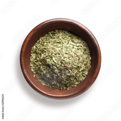 dried tarragon in a wooden bowl, isolated on white