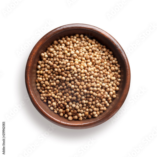 coriander in a wooden bowl, isolated on white